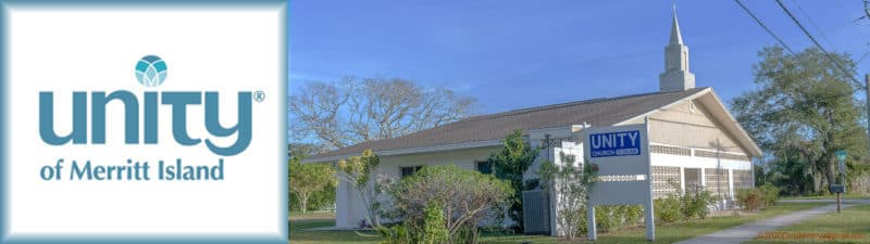 A white church with a steeple sits amidst green shrubs and trees, with a sign in front reading "Unity Church of Merritt Island," and a large logo for "Unity of Merritt Island" displayed on an adjacent board.